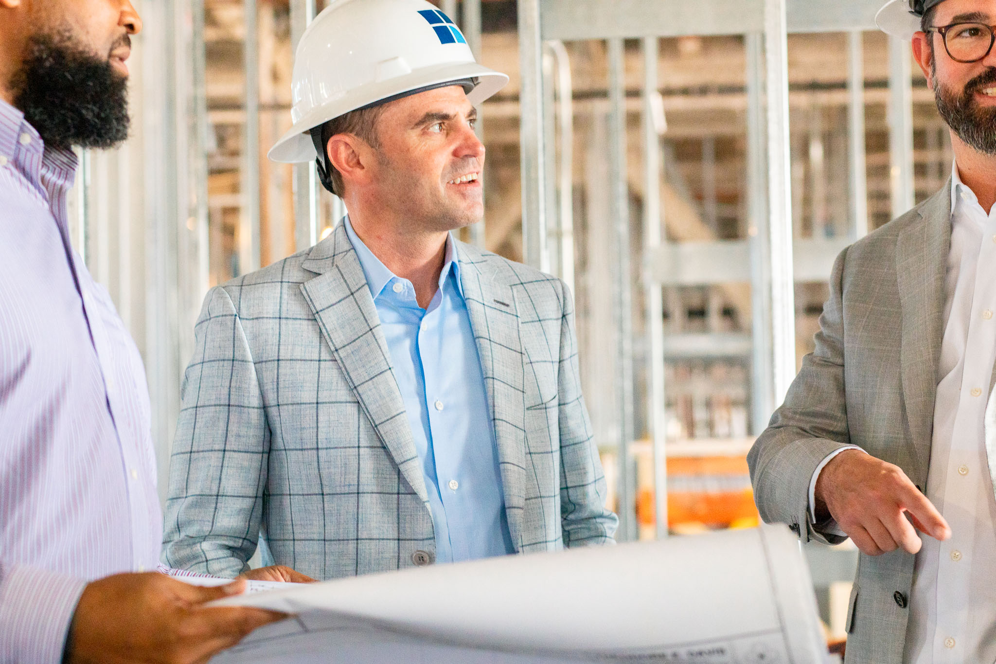man talking with a group of construction workers and architects