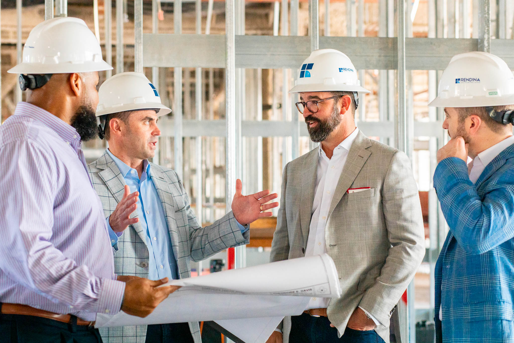 men discussing construction plans wearing hard hats